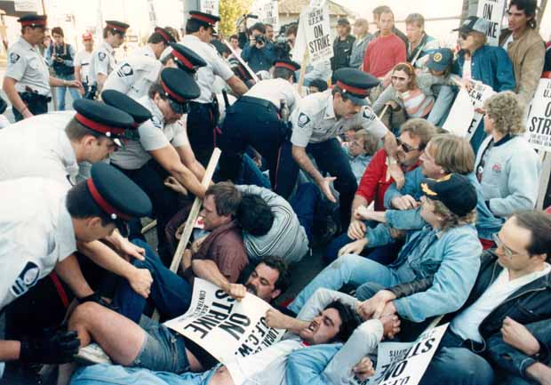 Police assist strikebreakers by clearing the entrance to Gainer's, 1986